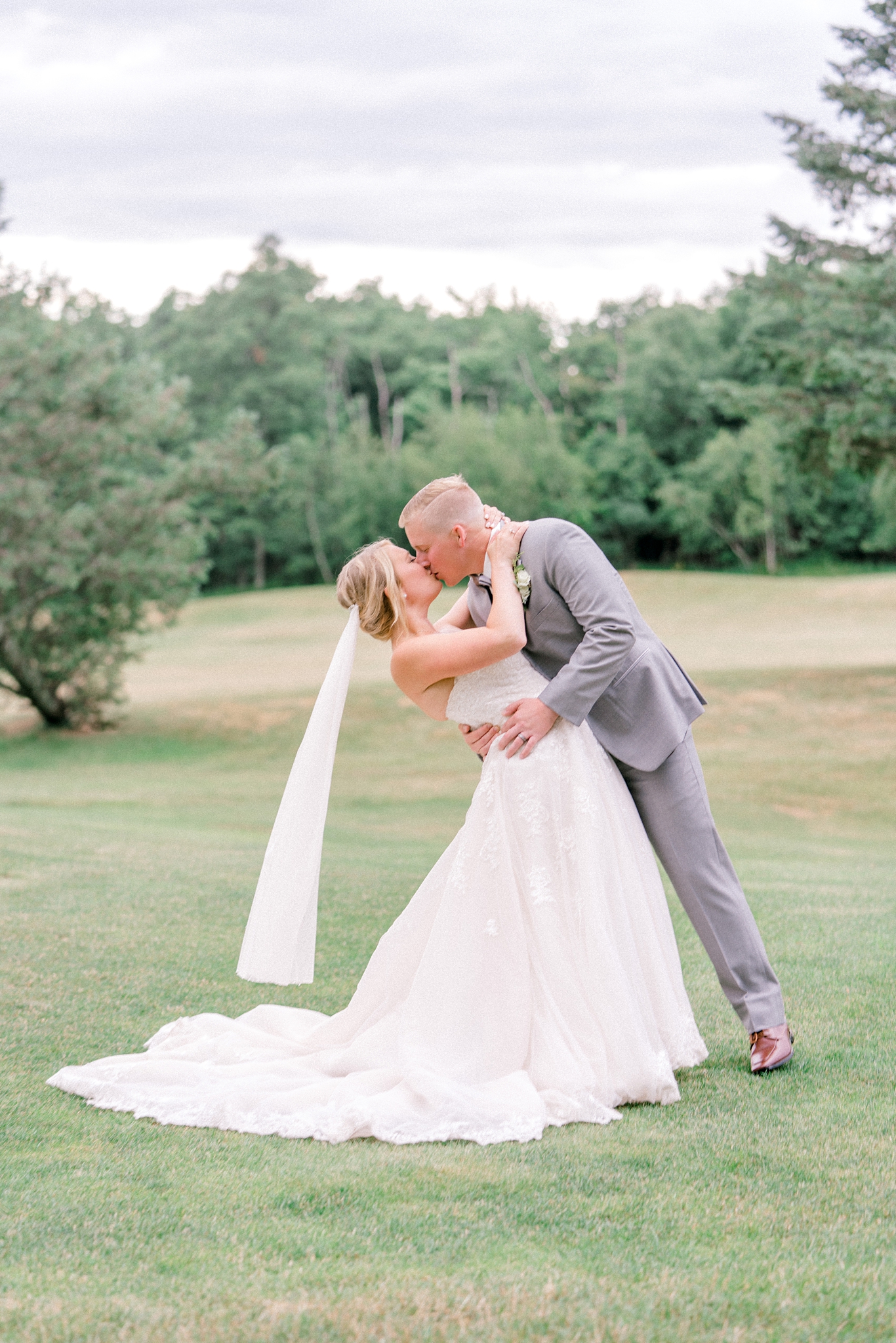 bride and groom kissing on a golf course